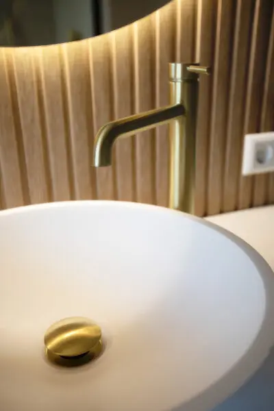 Wastafel met messing kraan en houten achterwand – villa Het Gooi